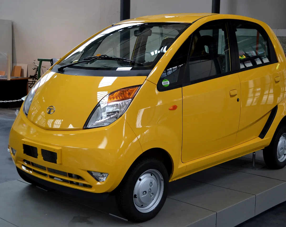 A yellow Tata Nano on display in a museum